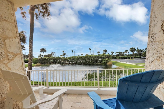 balcony with a water view and area for grilling