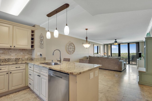 kitchen featuring cream cabinetry, a sink, stainless steel dishwasher, floor to ceiling windows, and a peninsula