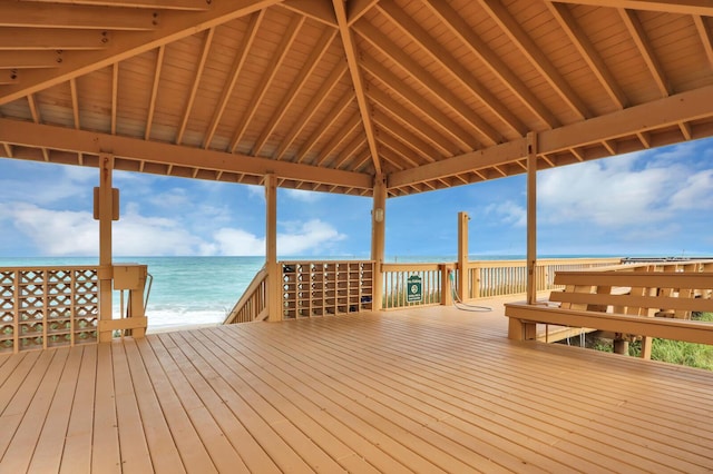 wooden terrace with a gazebo, a water view, and a beach view