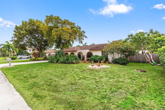 view of front of home featuring a front yard, fence, and stucco siding