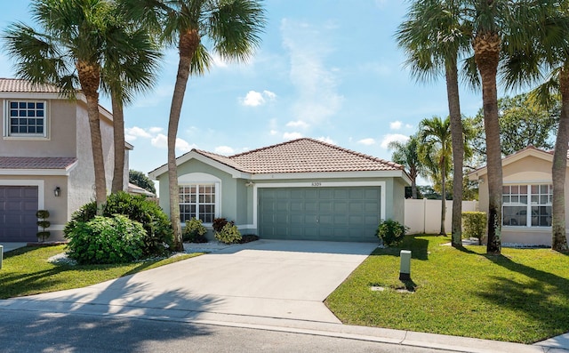 mediterranean / spanish-style house featuring a garage and a front yard