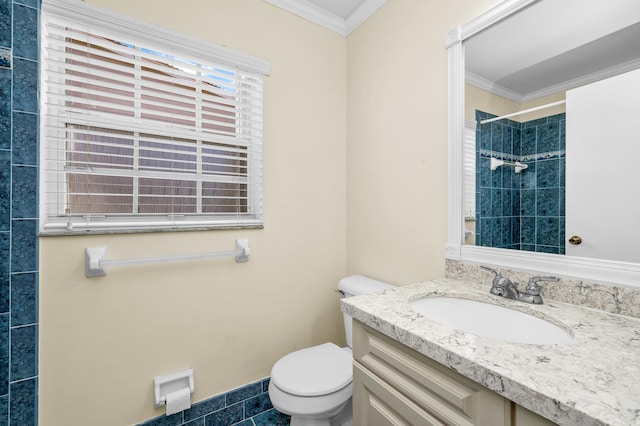 bathroom featuring tiled shower, ornamental molding, toilet, and vanity