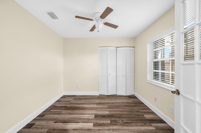 unfurnished bedroom featuring a closet, dark hardwood / wood-style floors, and ceiling fan