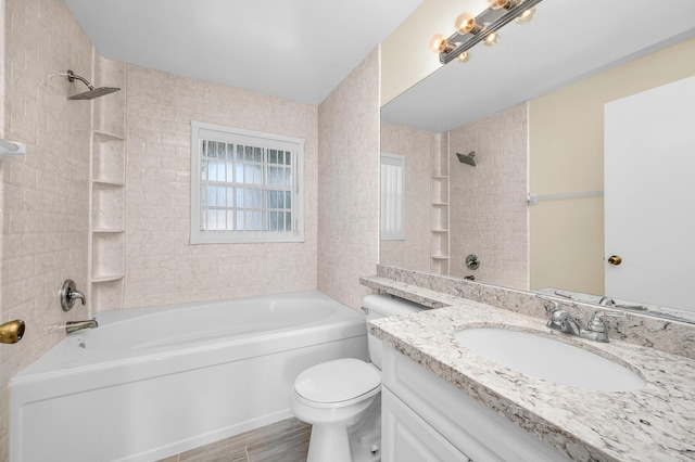 full bathroom featuring vanity, tiled shower / bath combo, and toilet