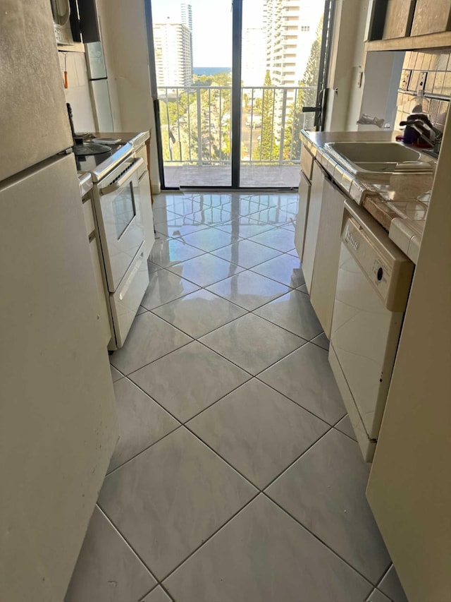290 174th St Unit 1111, Sunny Isles Beach, FL 33160 - kitchen with white appliances, tile counters, light tile patterned flooring, and a sink