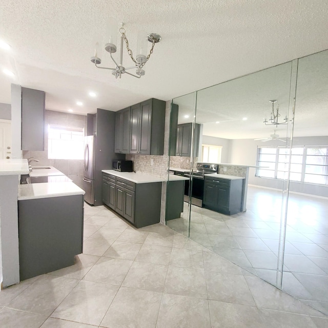 kitchen with tasteful backsplash, appliances with stainless steel finishes, a kitchen island, and hanging light fixtures