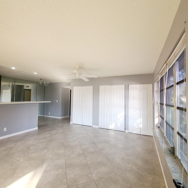 tiled spare room with ceiling fan and a textured ceiling