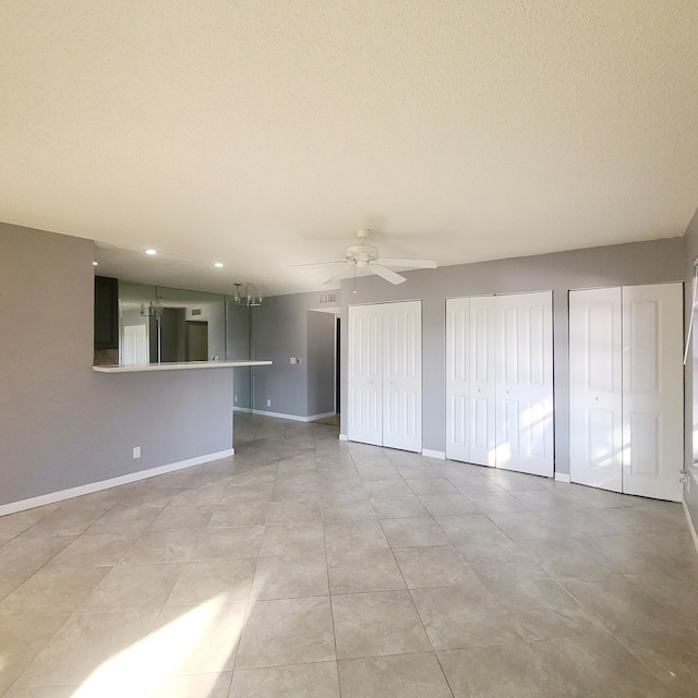 unfurnished living room with ceiling fan, a textured ceiling, and light tile patterned floors