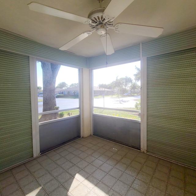 unfurnished sunroom with a water view and ceiling fan