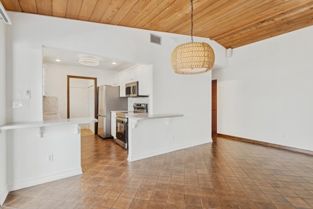 kitchen featuring white cabinetry, pendant lighting, a kitchen breakfast bar, and stainless steel appliances