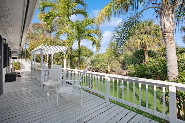 wooden terrace featuring a yard and a pergola