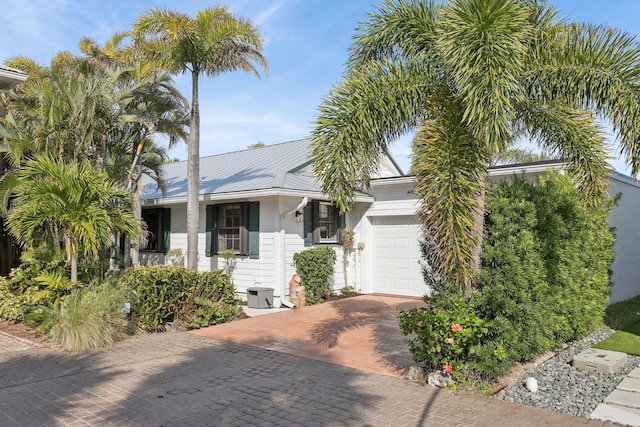 view of front of property with a garage and central AC unit