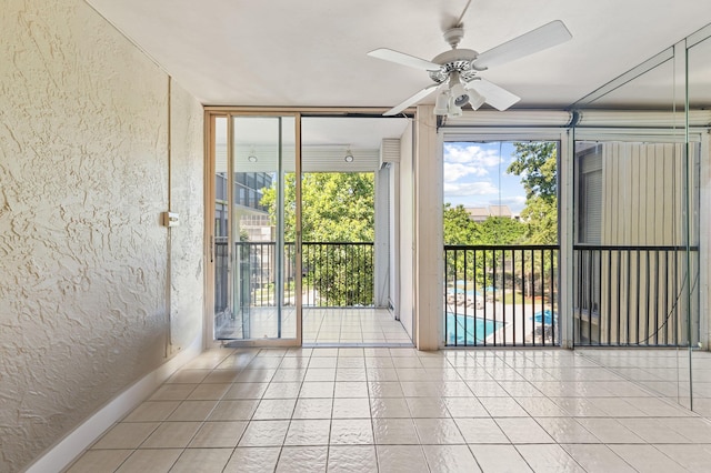 2802 N 46th Ave Unit B513, Hollywood, FL 33021 - tiled spare room featuring ceiling fan, a wall of windows, a textured wall, and a healthy amount of sunlight