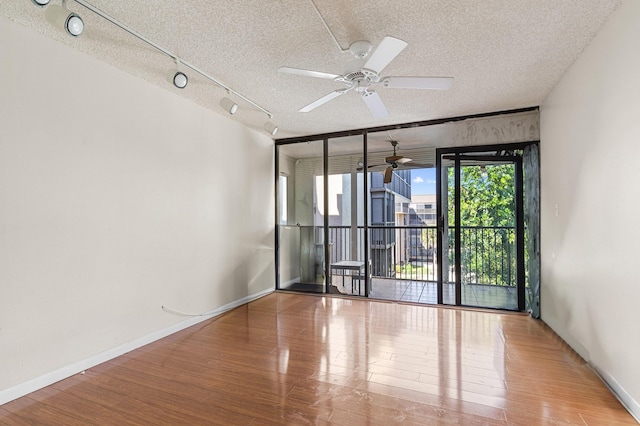 2802 N 46th Ave Unit B513, Hollywood, FL 33021 - spare room featuring a ceiling fan, wood finished floors, baseboards, track lighting, and a textured ceiling