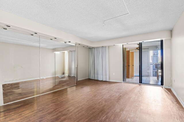 2802 N 46th Ave Unit B513, Hollywood, FL 33021 - unfurnished bedroom with access to exterior, a textured ceiling, baseboards, and wood finished floors