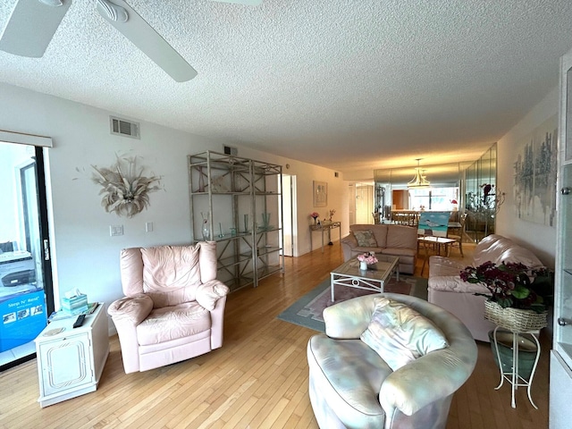 living room featuring a textured ceiling and light wood-type flooring