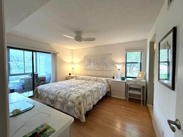 bedroom with ceiling fan, access to outside, a textured ceiling, and light wood-type flooring