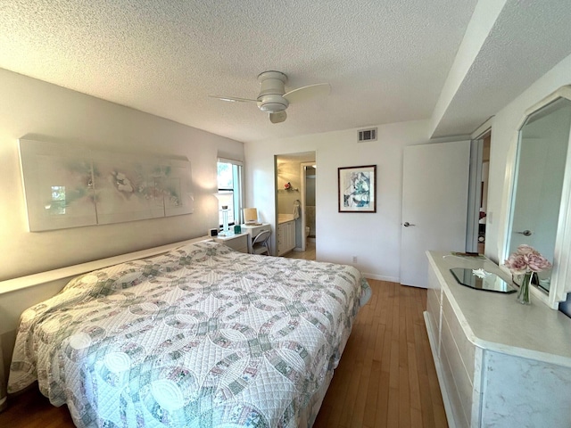 bedroom featuring ceiling fan, hardwood / wood-style flooring, and a textured ceiling