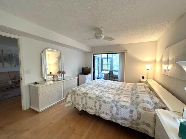 bedroom with a textured ceiling, ceiling fan, and light wood-type flooring