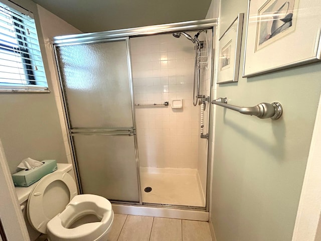 bathroom featuring toilet and a shower with shower door