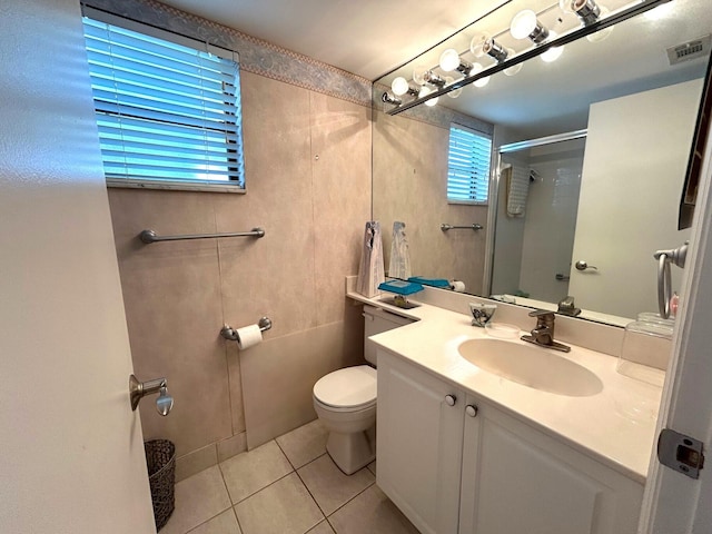 bathroom featuring toilet, vanity, tile patterned floors, and walk in shower