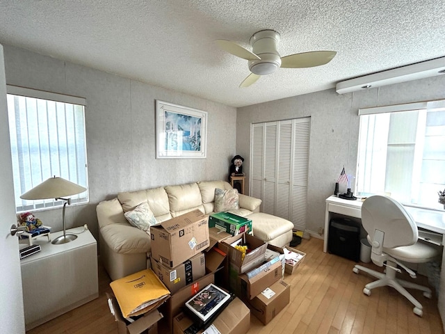 office with ceiling fan, a textured ceiling, and light hardwood / wood-style floors