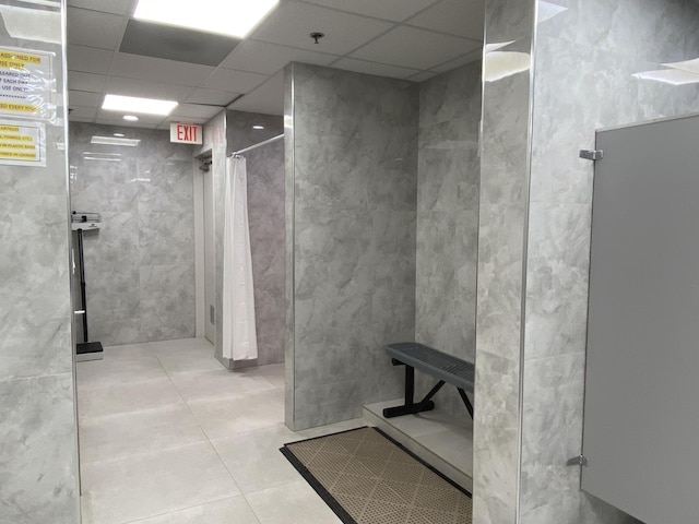 bathroom with walk in shower, tile patterned flooring, and a drop ceiling