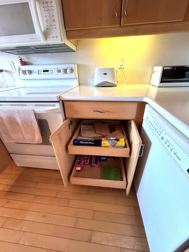 kitchen featuring light wood-type flooring and white appliances