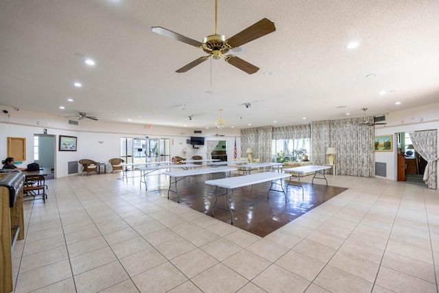 interior space with a healthy amount of sunlight, light tile patterned floors, and a textured ceiling