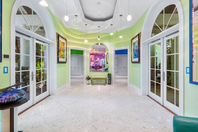 rec room with ornamental molding, a tray ceiling, french doors, and arched walkways