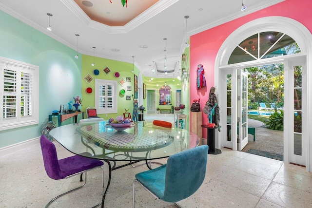 dining space with baseboards, a tray ceiling, and crown molding