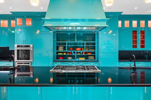 interior space featuring island range hood, dark countertops, glass insert cabinets, stainless steel double oven, and a sink