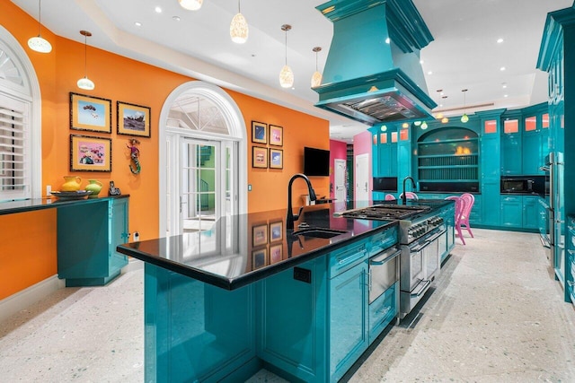 kitchen featuring dark countertops, decorative light fixtures, a sink, and island exhaust hood