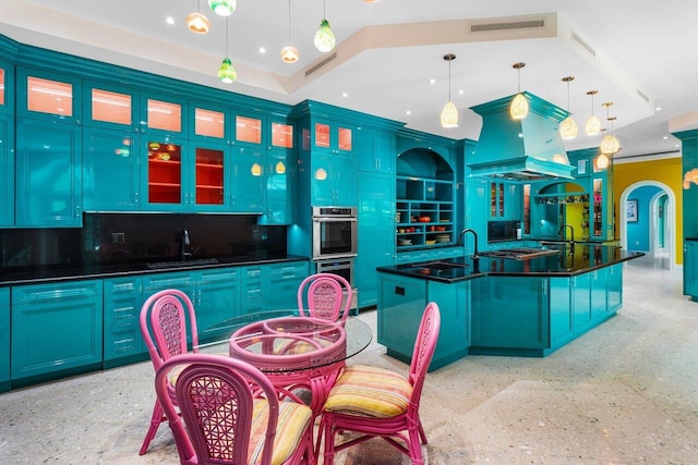 kitchen featuring a kitchen island with sink, decorative light fixtures, and blue cabinetry