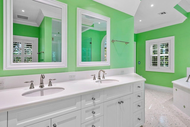 full bath with ornamental molding, a sink, baseboards, and double vanity