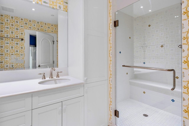 full bathroom with a stall shower, visible vents, vanity, and wallpapered walls