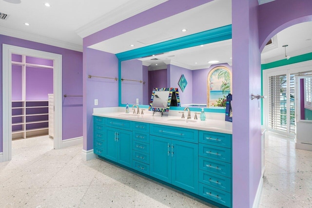 full bath featuring double vanity, visible vents, ornamental molding, a sink, and baseboards