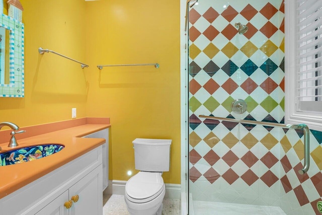 bathroom featuring toilet, tiled shower, and vanity