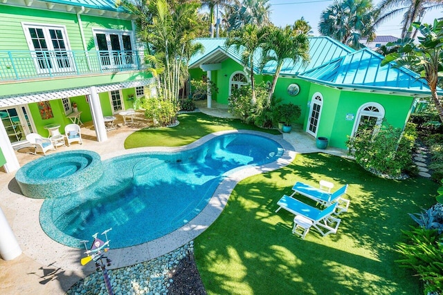 view of swimming pool with a patio area, a lawn, and an in ground hot tub