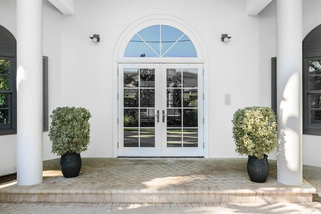 doorway to property with french doors, a patio area, and stucco siding