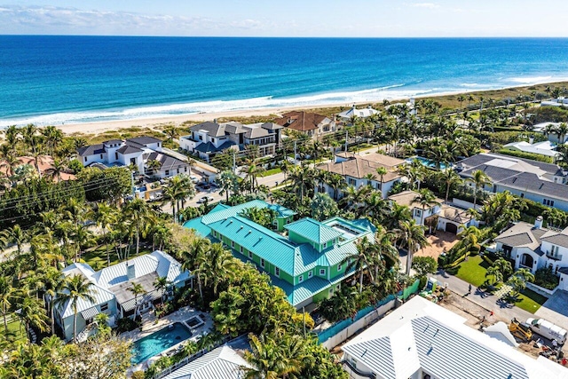 drone / aerial view featuring a water view, a residential view, and a view of the beach