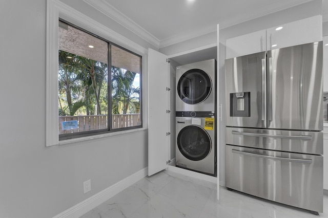 laundry room featuring crown molding and stacked washer and clothes dryer