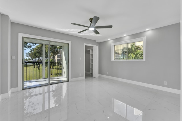 empty room featuring a wealth of natural light and ceiling fan