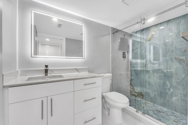 bathroom featuring vanity, a shower with door, and toilet