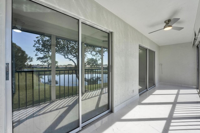 balcony featuring a water view and ceiling fan