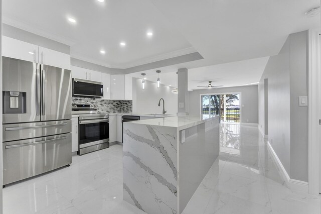 kitchen featuring pendant lighting, sink, appliances with stainless steel finishes, white cabinetry, and kitchen peninsula