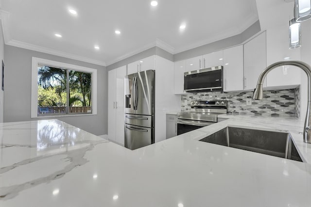 kitchen with sink, white cabinets, stainless steel appliances, crown molding, and light stone countertops