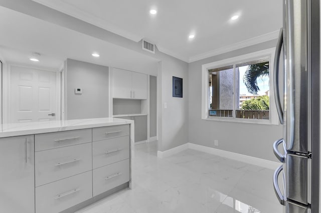 interior space featuring white cabinetry, crown molding, light stone countertops, and stainless steel refrigerator