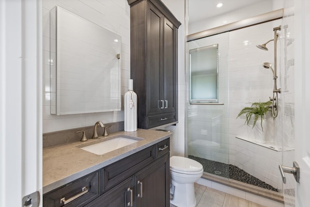 full bathroom featuring vanity, toilet, and a stall shower