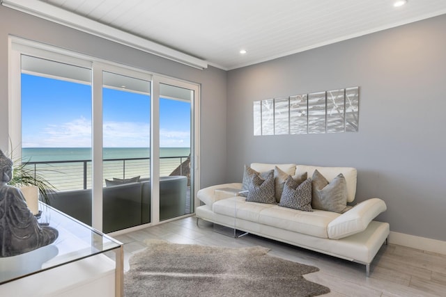 living room featuring a wealth of natural light, baseboards, recessed lighting, and a water view